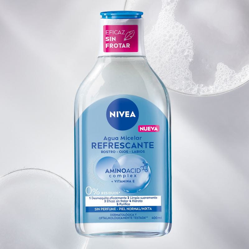 A bottle of NIVEA Micellar Water for Dry Skin lays on a red bubble textured background.