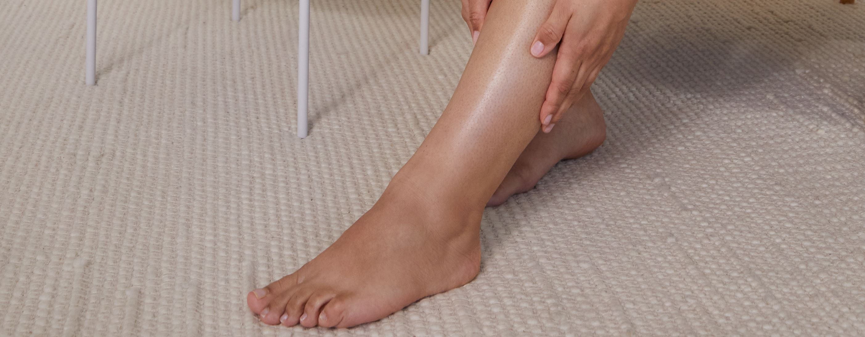 woman applying lotion to feet