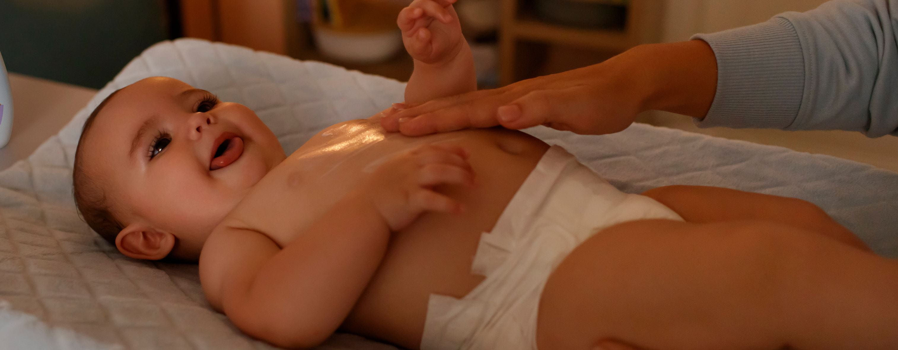 Ein lächelndes Baby bekommt eine Massage