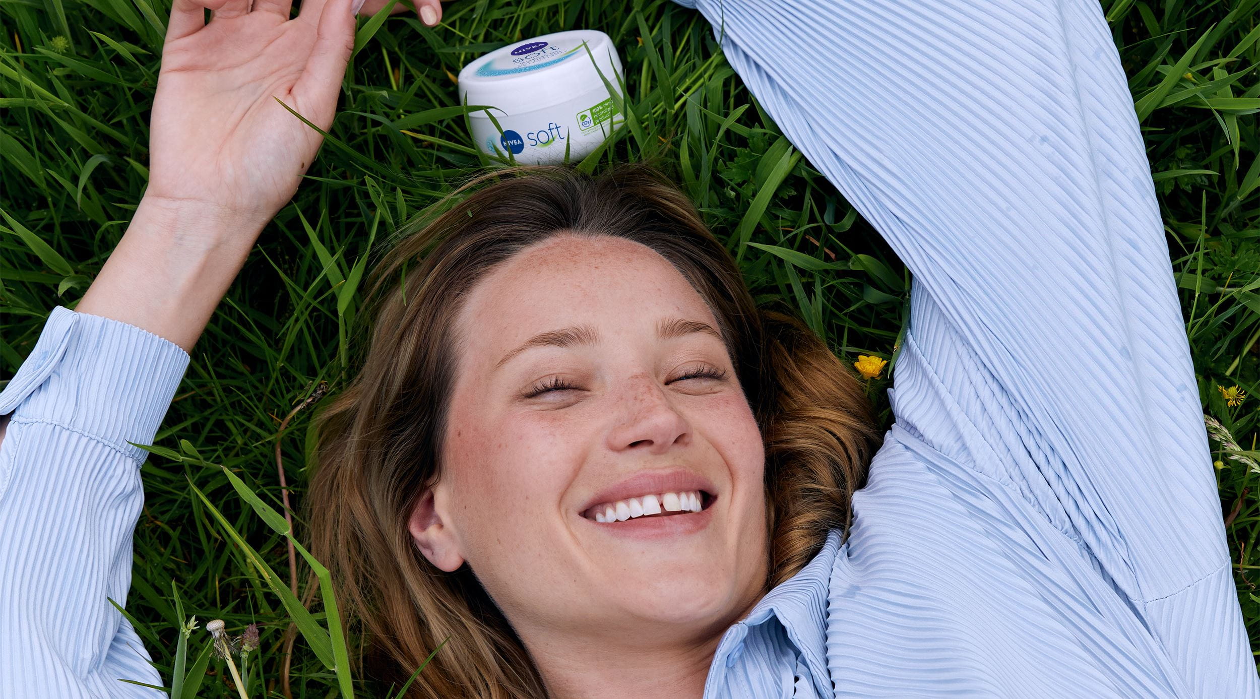Kobieta leżąca na trawie, uśmiechnięta