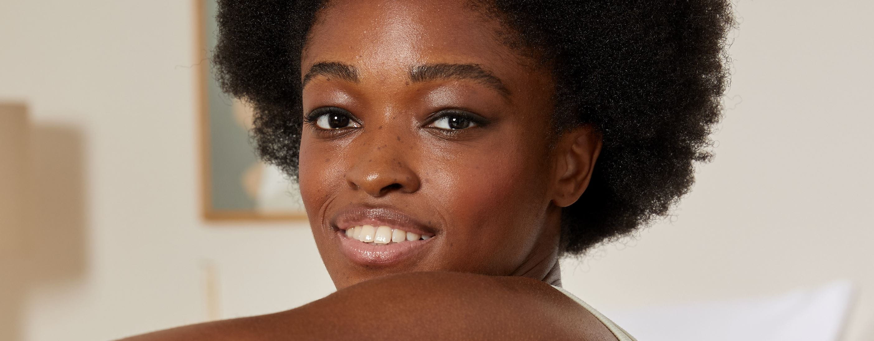 vrouw met afro-getextureerd haar, glimlachend