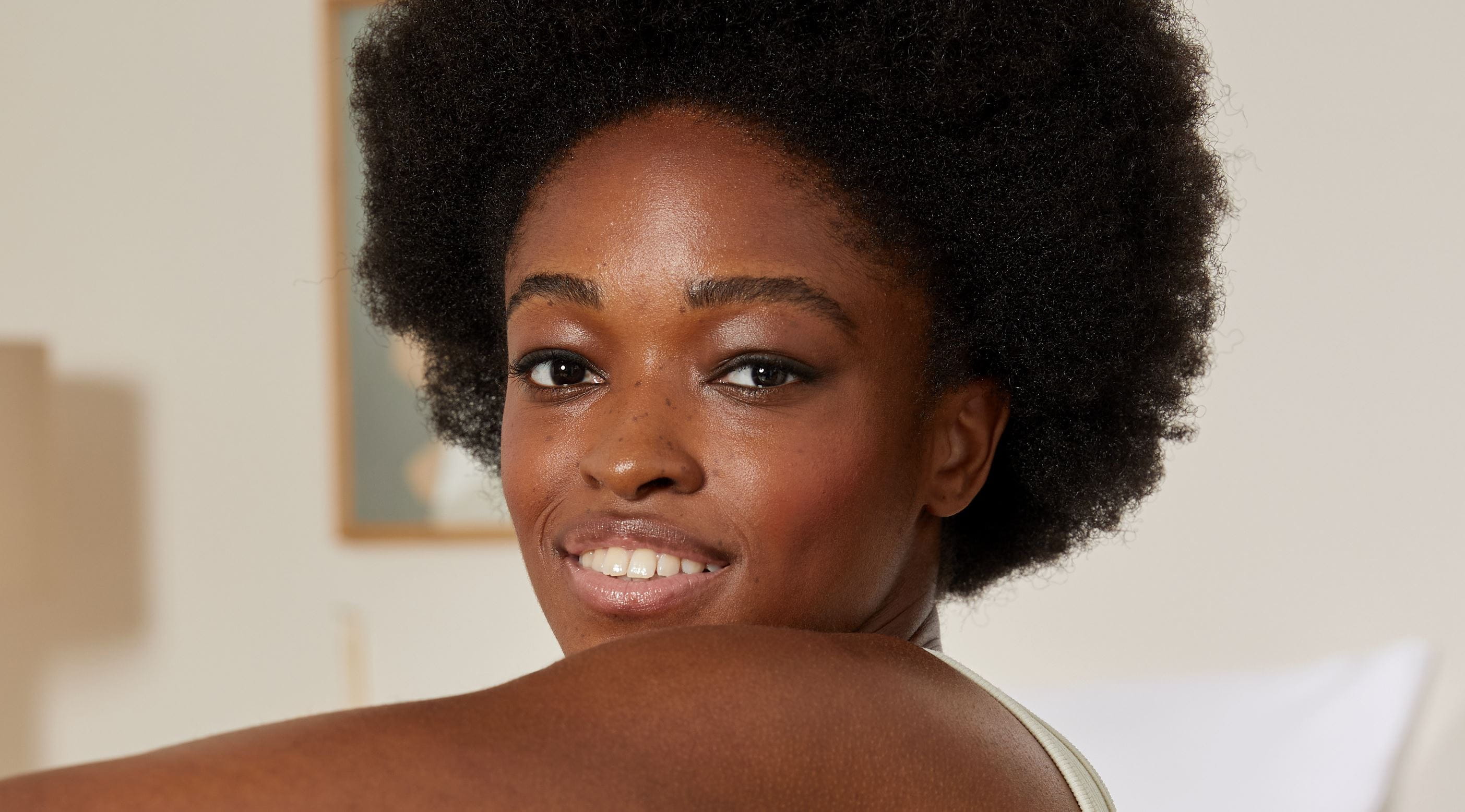 woman with afro-textured hair, smiling