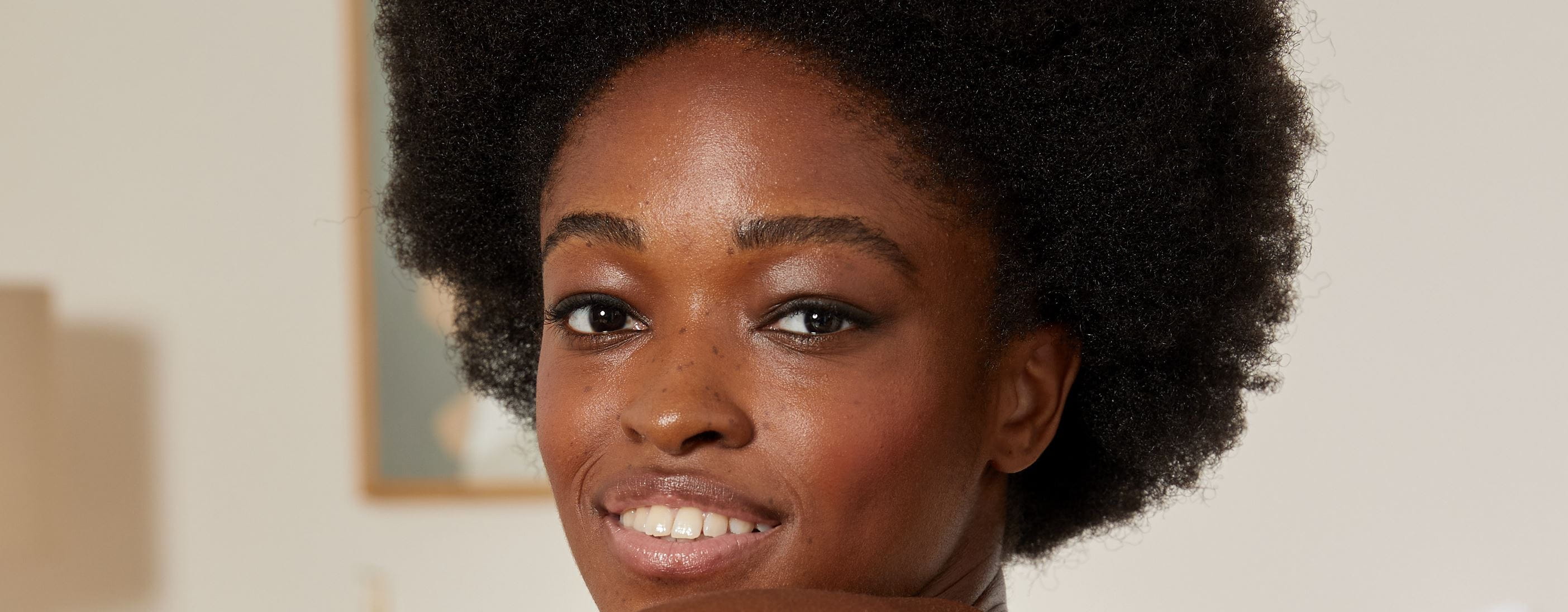 kobieta z włosami z teksturą afro, uśmiechając się