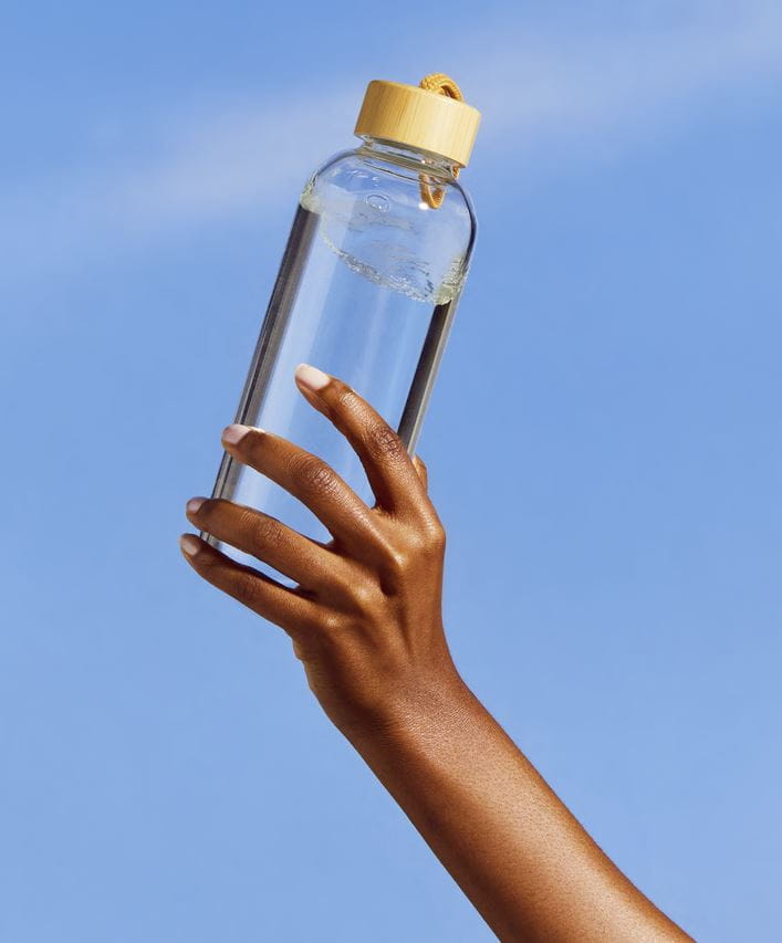 ruka drží fľašu vody
