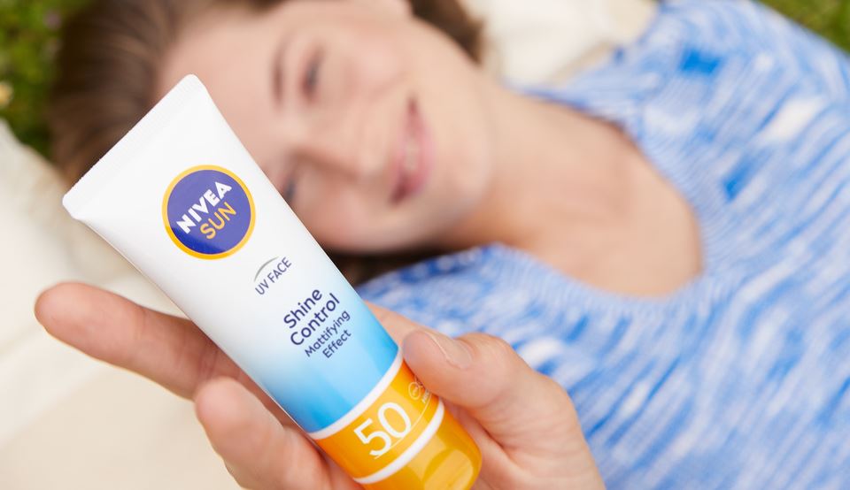 woman holding nivea face sunscreen