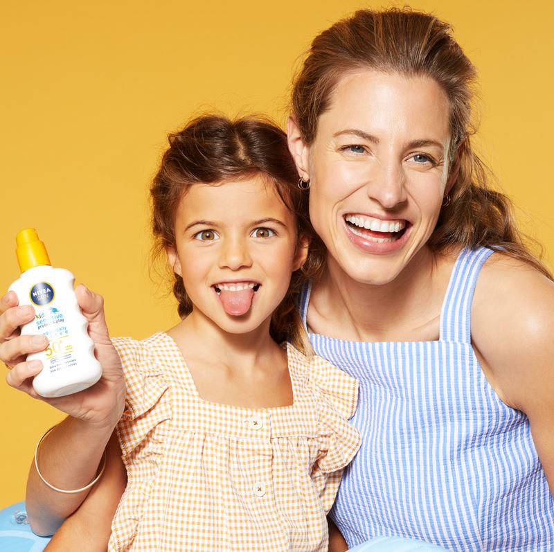 mother and daughter applying sun lotion