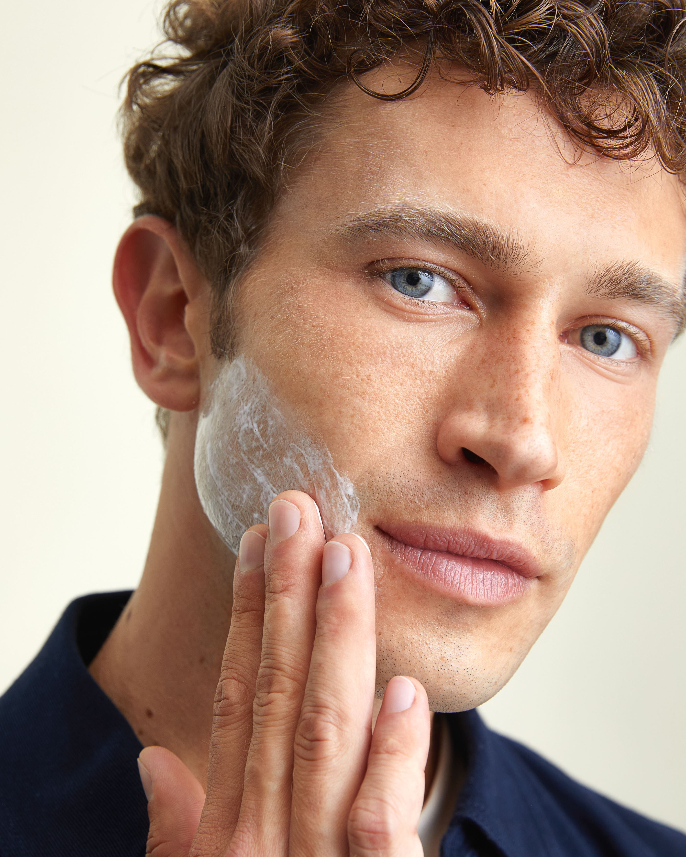 young man applying Nivea cream on his face