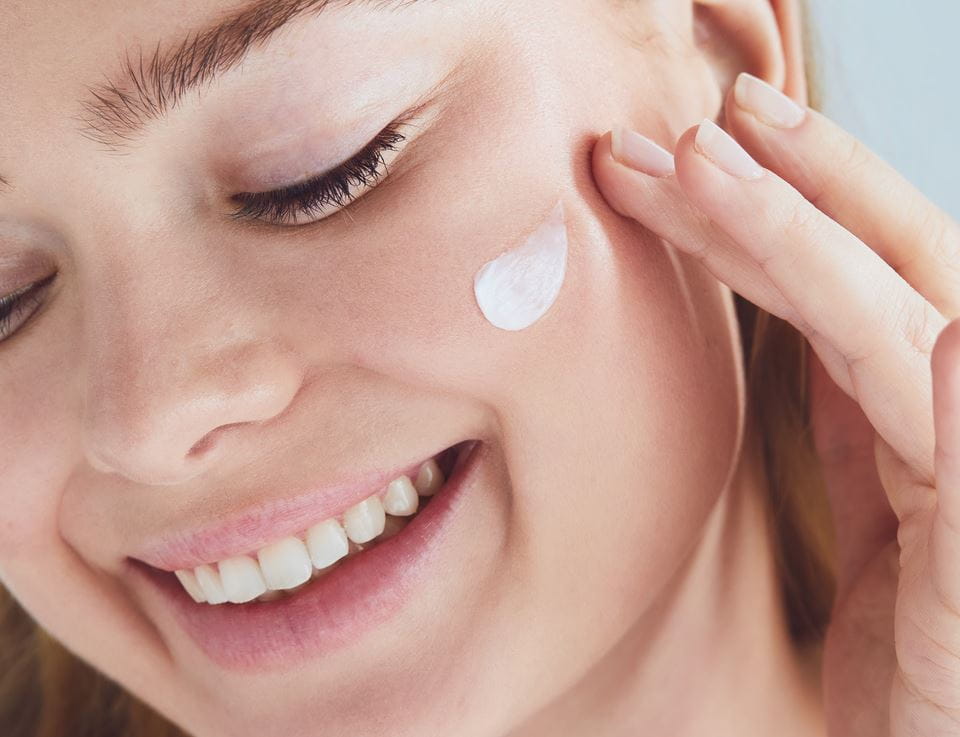 young woman applying Nivea face cream