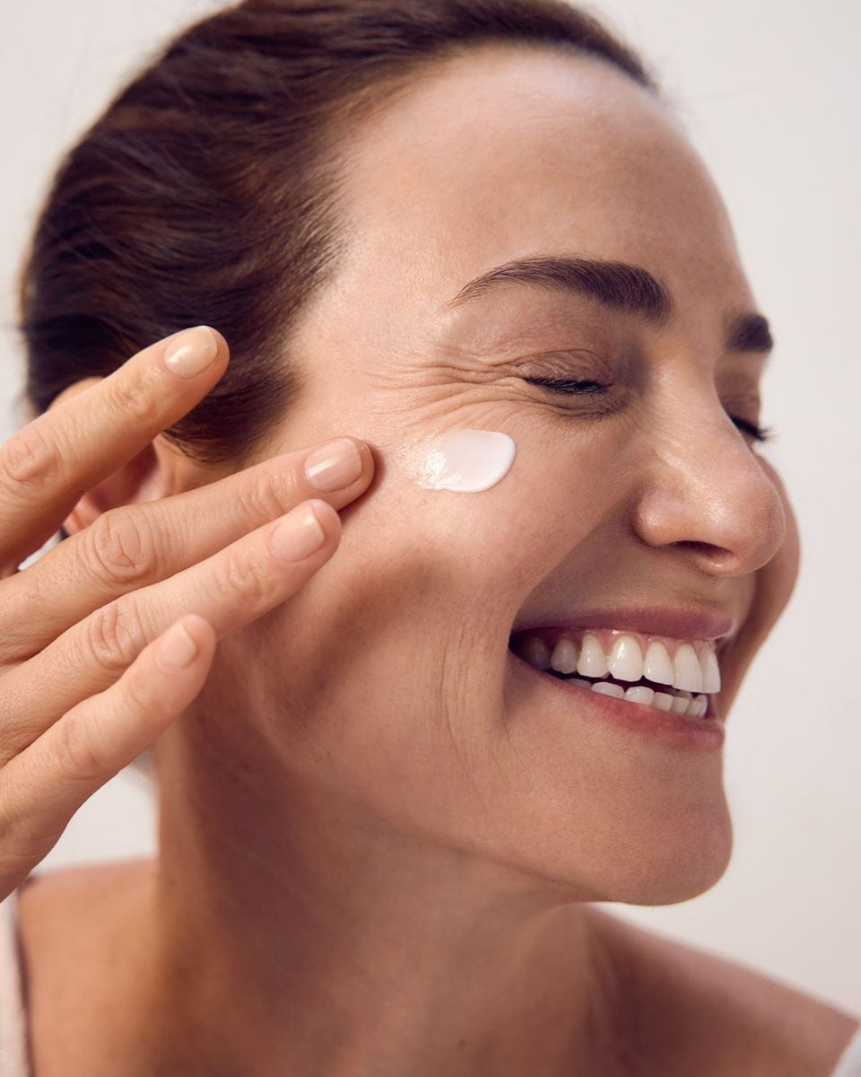 Mujer aplicando crema hidratante facial Nivea