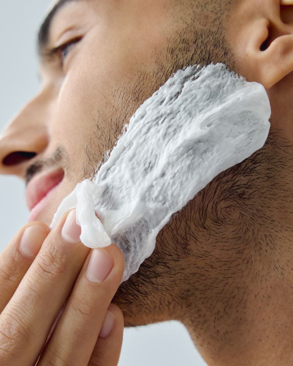 man applying Nivea shaving foam on his face
