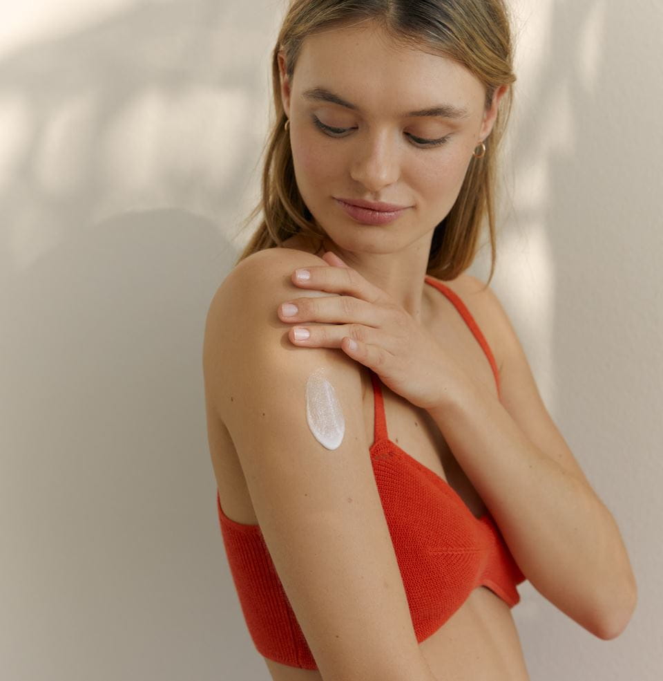 young woman applying Nivea self tan body lotion