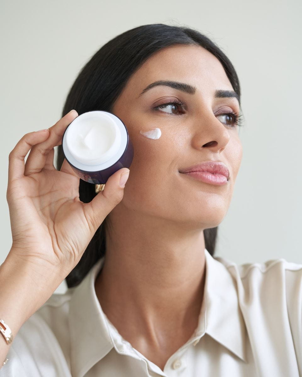 Mujer que usa la crema facial Nivea Cellular Luminous630
