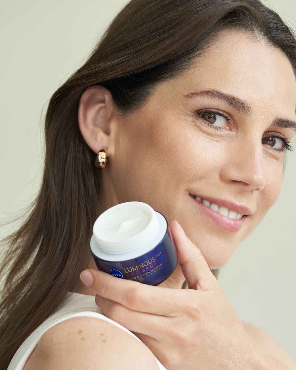femme tenant une crème pour le visage Nivea Cellular Luminous630
