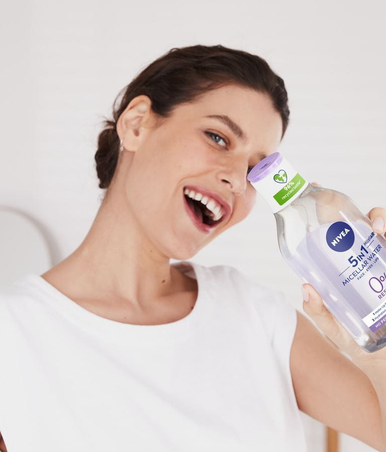 Junge Frau verwendet 5-in-1-Mizellenwasser von Nivea