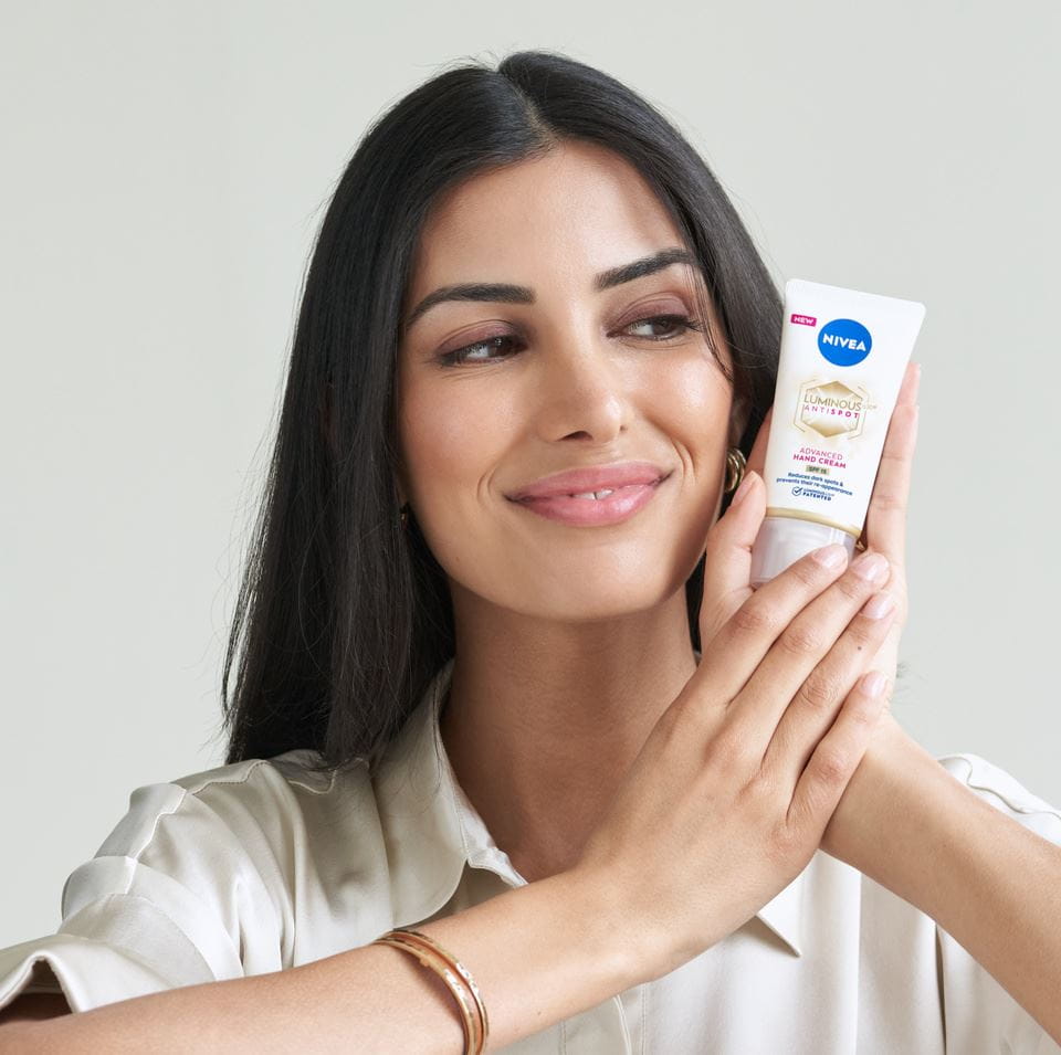jonge vrouw die Nivea Luminous Anti Spot Handcrème gebruikt