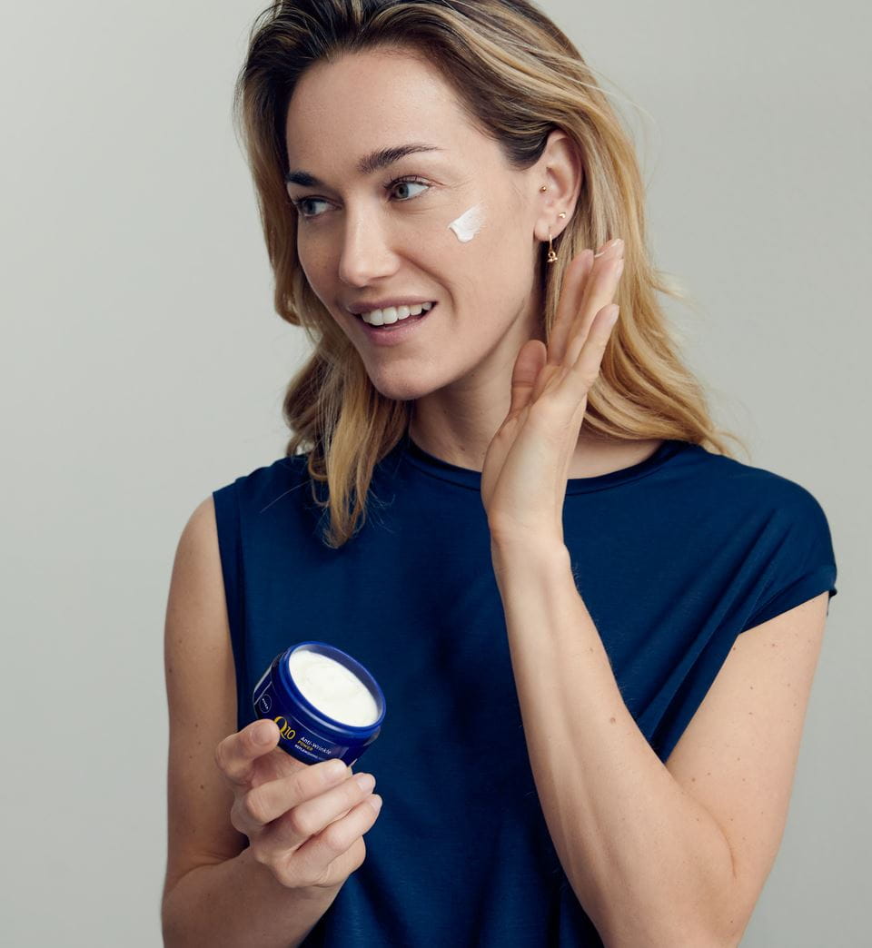 woman applying Nivea Q10 face cream