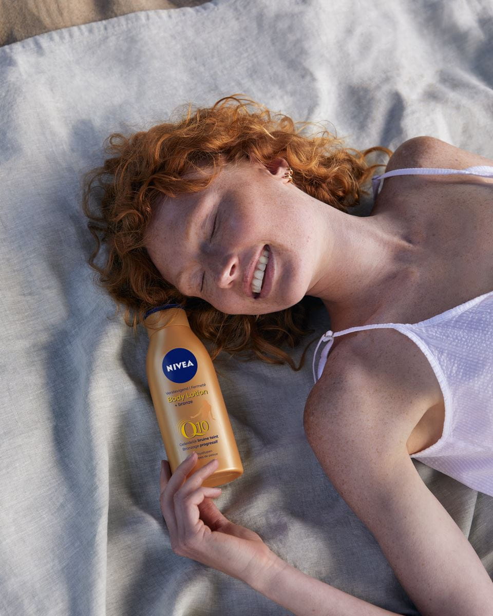 young woman using Nivea self tab lotion