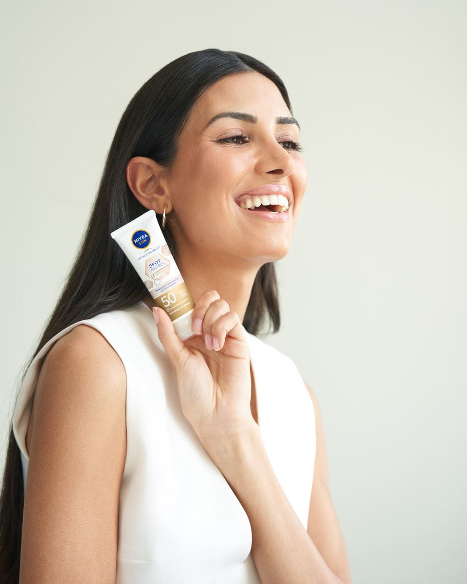 young woman using Nivea Sun Spot Control face cream