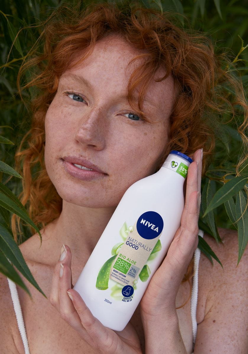 woman holding a bottle of Nivea Body Lotion