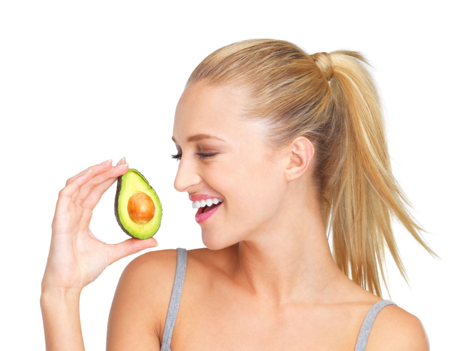 lady smiling while holding an avocado