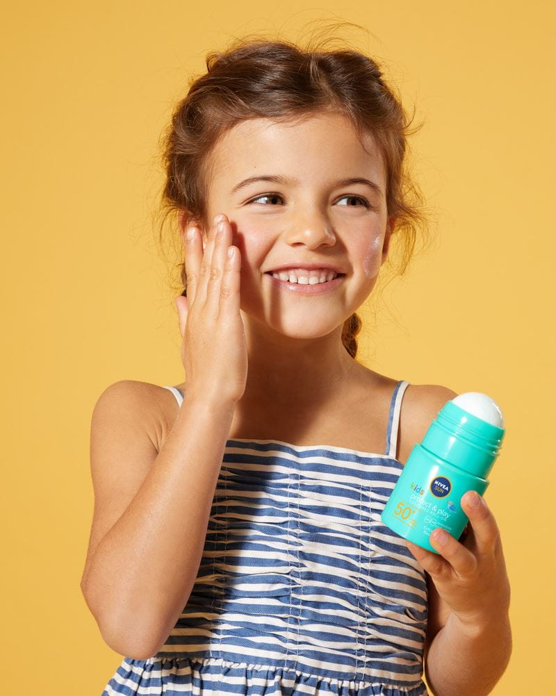 klein meisje gebruikt Nivea zonnebrandcrème roll-on
