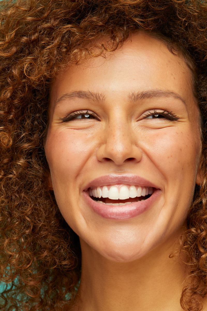 woman with curly hair, smiling