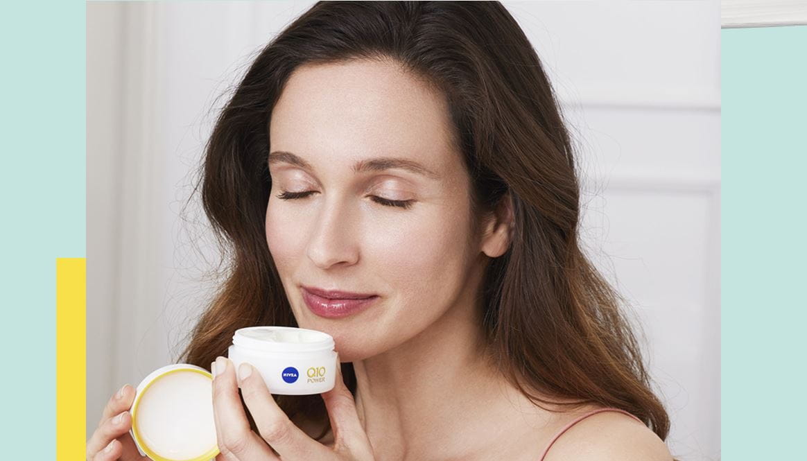 Lady smiling using anti aging cream with creatine