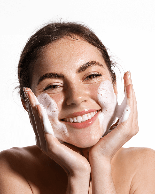 Mujer lavando su rostro con skincare.