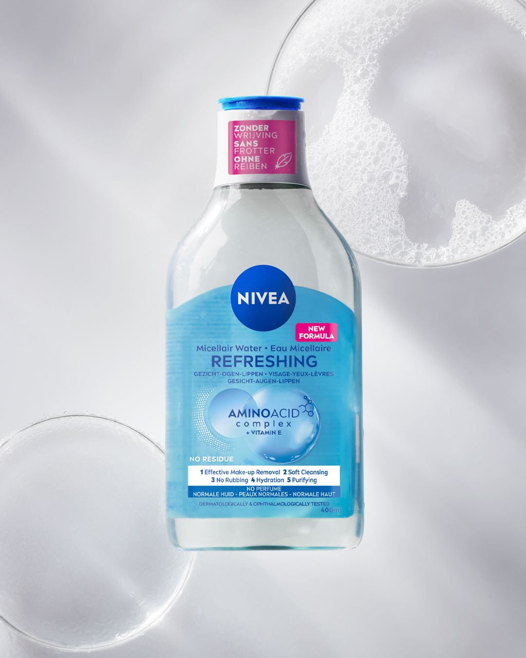 Een flesje NIVEA Micellair Water voor alle huidtypes ligt op een zwarte bubbelachtige achtergrond.