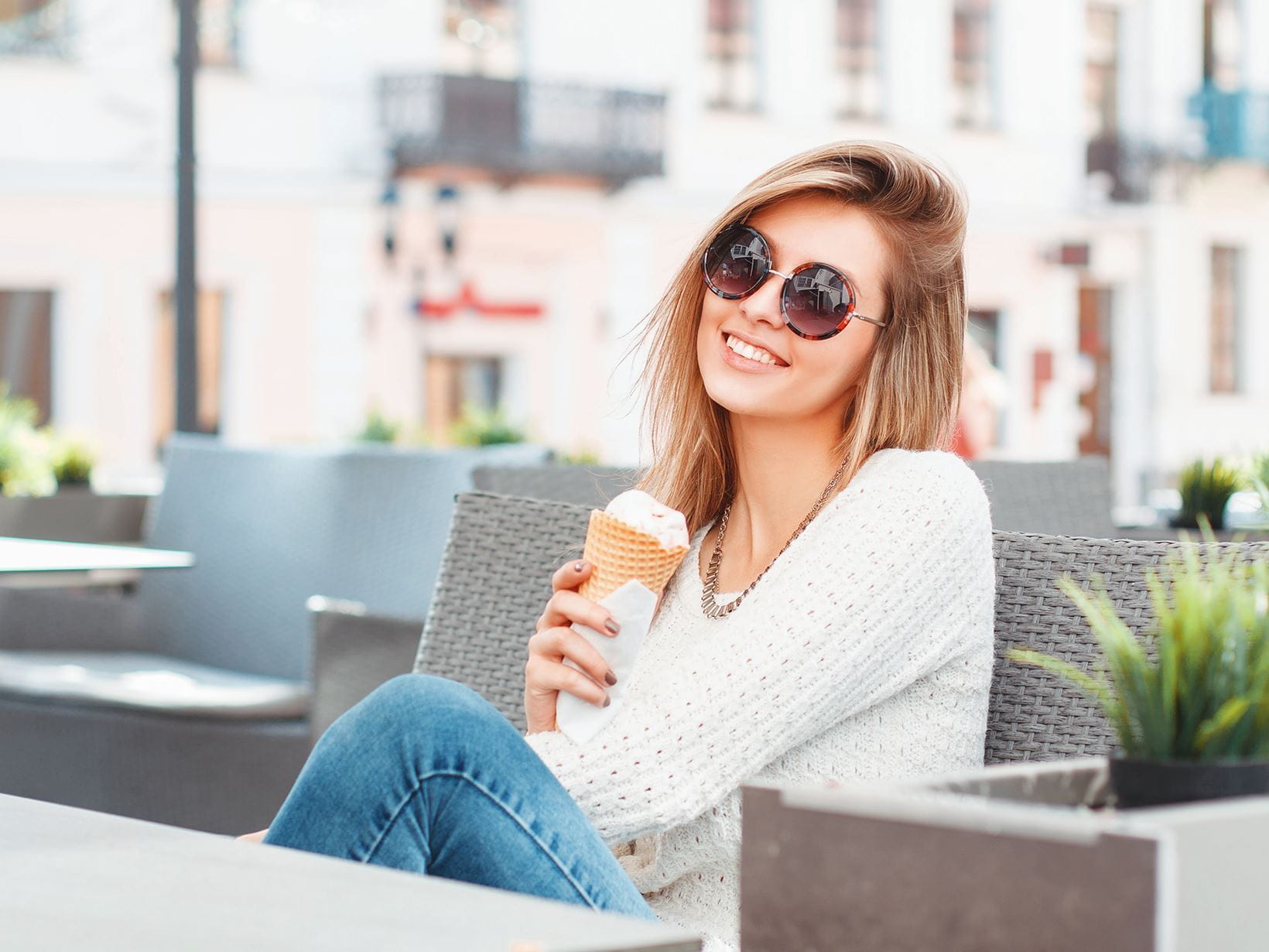 Mulher de óculos de sol a comer um gelado