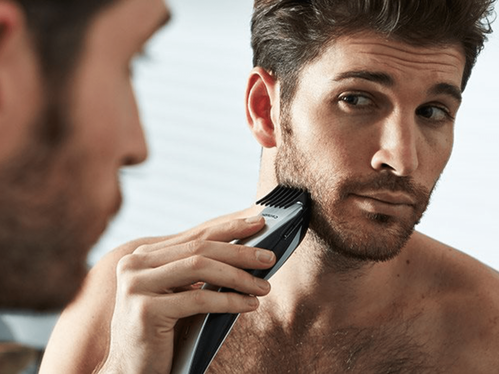 homem a usar uma máquina de barbear